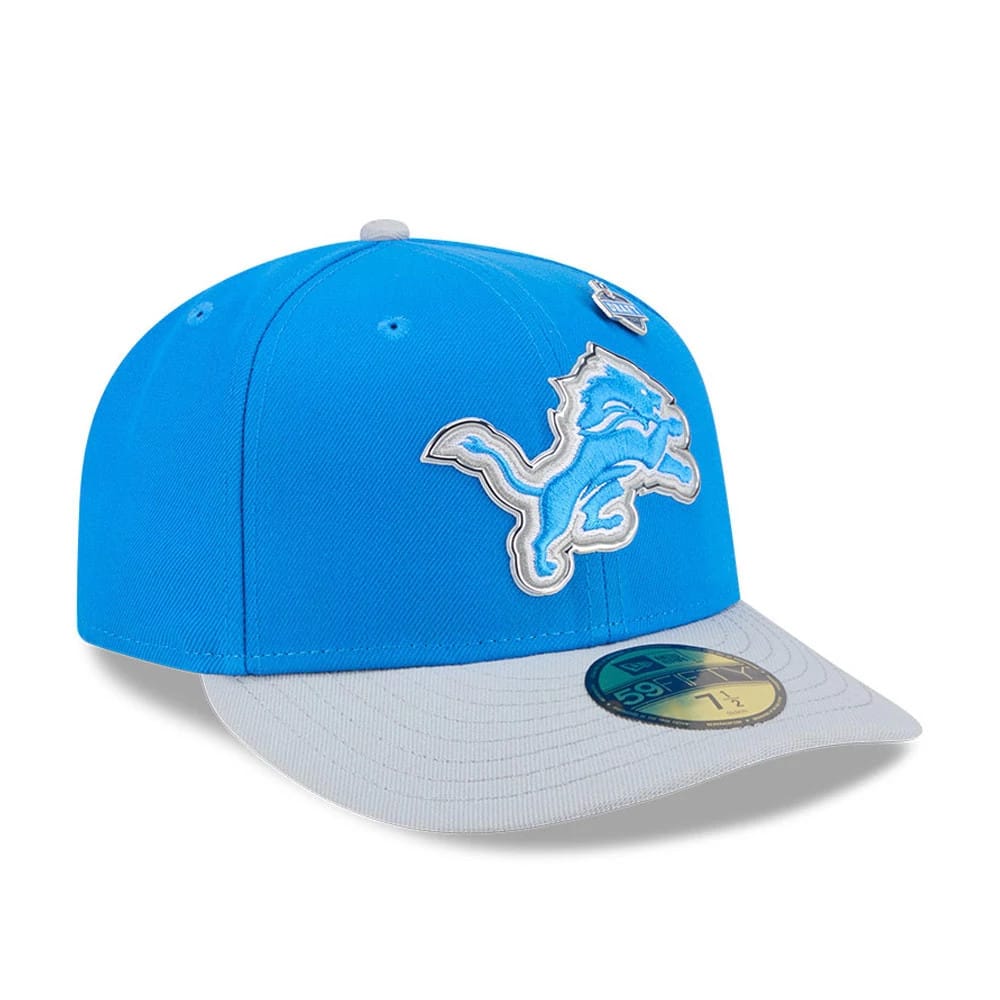 Detroit Lions NFL Draft 2026 Blue New Era 59FIFTY Fitted Cap, three-quarter view showing the silver and white embroidered lion logo on the front panel, a grey visor with a gold 59FIFTY size sticker, and a round NFL pin on the crown.