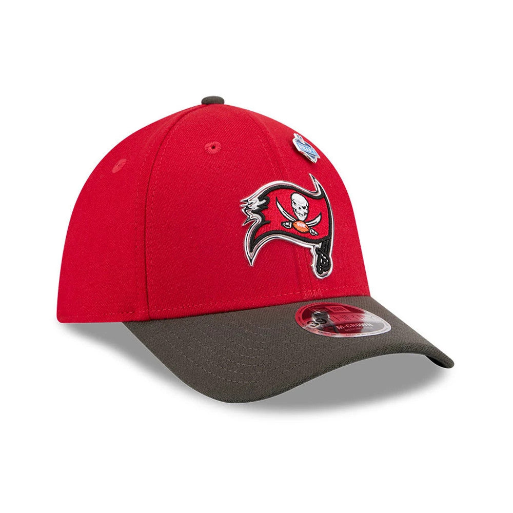 Tampa Bay Buccaneers NFL Draft 2026 Red New Era 39THIRTY M-Crown Stretch Fit Cap, three-quarter view showing the raised embroidered Buccaneers logo on the front panel, brown curved visor with 39THIRTY size sticker, and dark grey top button.