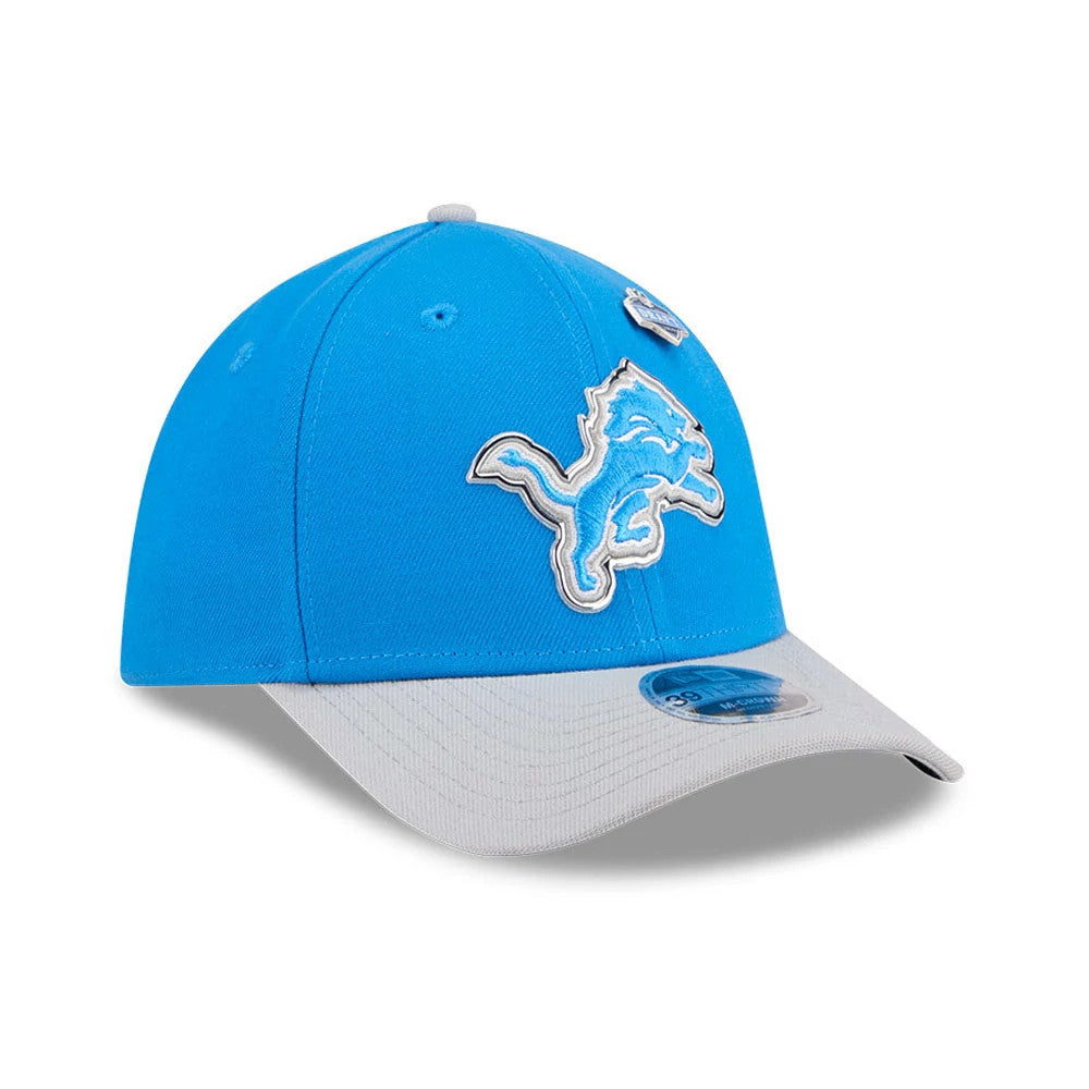 Detroit Lions NFL Draft 2026 Blue New Era 39THIRTY M-Crown Stretch Fit Cap, three-quarter view showing the raised embroidered white and blue Detroit Lions logo on the front panel, grey curved visor with blue 39THIRTY size sticker.