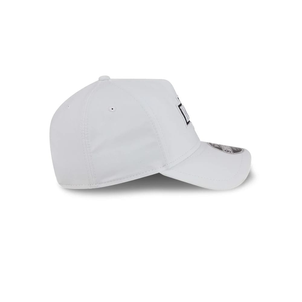 LA Kings NHL Quickstrike White New Era 9FORTY Apex Adjustable Cap, side view showing the white structured crown with embroidered eyelets, a curved white visor, and the partially 9FORTY size sticker on the top of the visor.