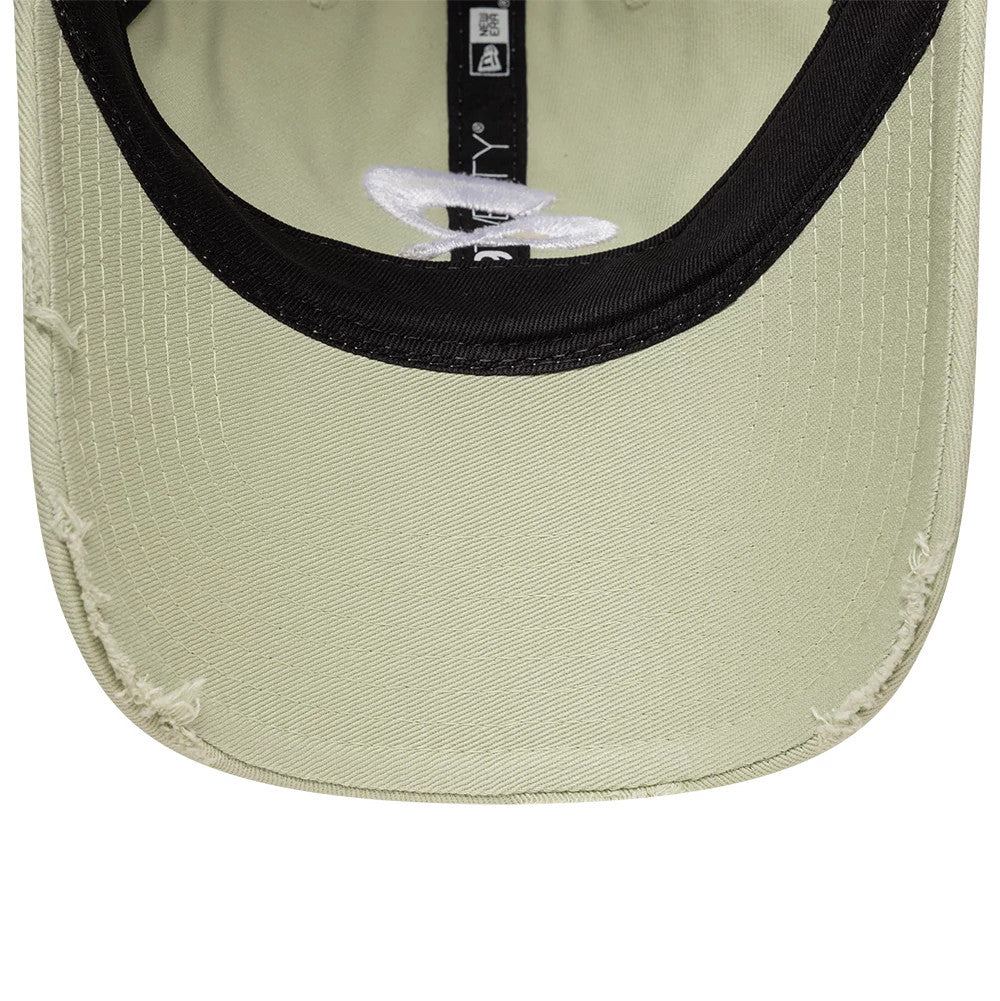 Quadrant X New Era Distressed Pastel Green 9TWENTY Cap, inside view showing the black taping along the seams with white lettering, a contrasting black sweatband, and a distressed detail on the pastel green undervisor edge.