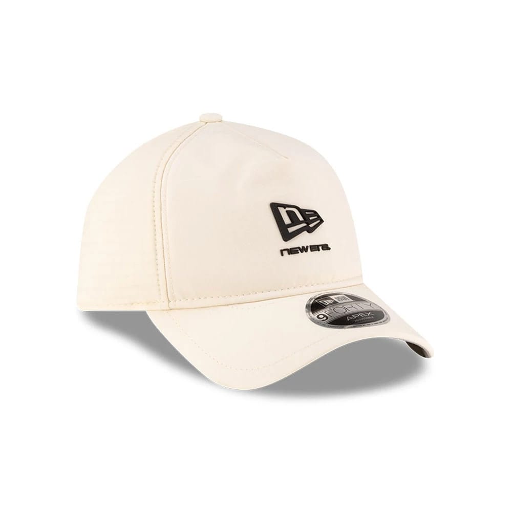 New Era Light Beige 9FORTY Apex Cap, three-quarter view showing the black raised embroidered New Era flag logo on the front panel, the rounded light beige visor with a 9FORTY size sticker, and the structured crown design.