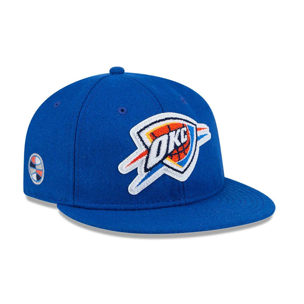 Oklahoma City Thunder NBA Chenille Woven Blue Retro Crown New Era 9FIFTY Cap, three-quarter view showing the large white embroidered OKC logo on the front panel, blue flat visor, and embroidered team logo patch on the left side.