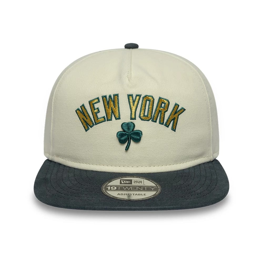 New York Yankees MLB Metallic Logo Cream New Era 19TWENTY Adjustable Cap, front view showing green and gold embroidered New York lettering above a green shamrock, a dark grey visor, and the 19TWENTY size sticker on the flat visor.