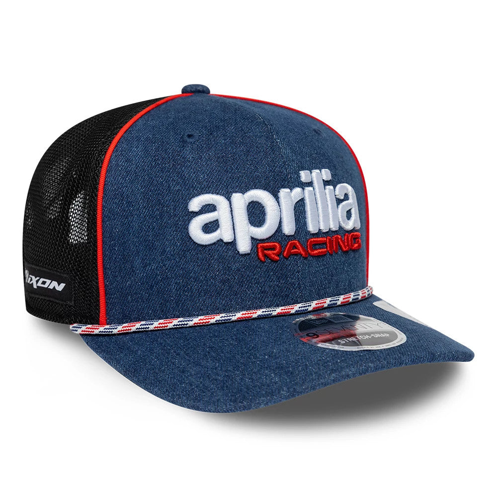 Aprilia Replica Austin Race Special Blue New Era 9SEVENTY Stretch Snap Adjustable Cap, three-quarter view showing the white and red embroidered aprilia racing logo on the blue front panels, with a black mesh rear and red piping detail.