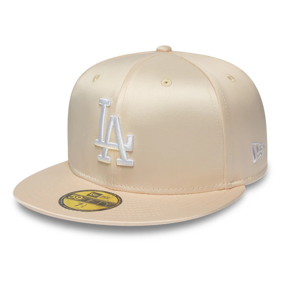 LA Dodgers MLB Satin Cream New Era 59FIFTY Fitted Cap, three-quarter view showing the white raised embroidered LA logo on the front panel, a cream flat visor with a gold 59FIFTY size sticker, and New Era flag logo on the left side.