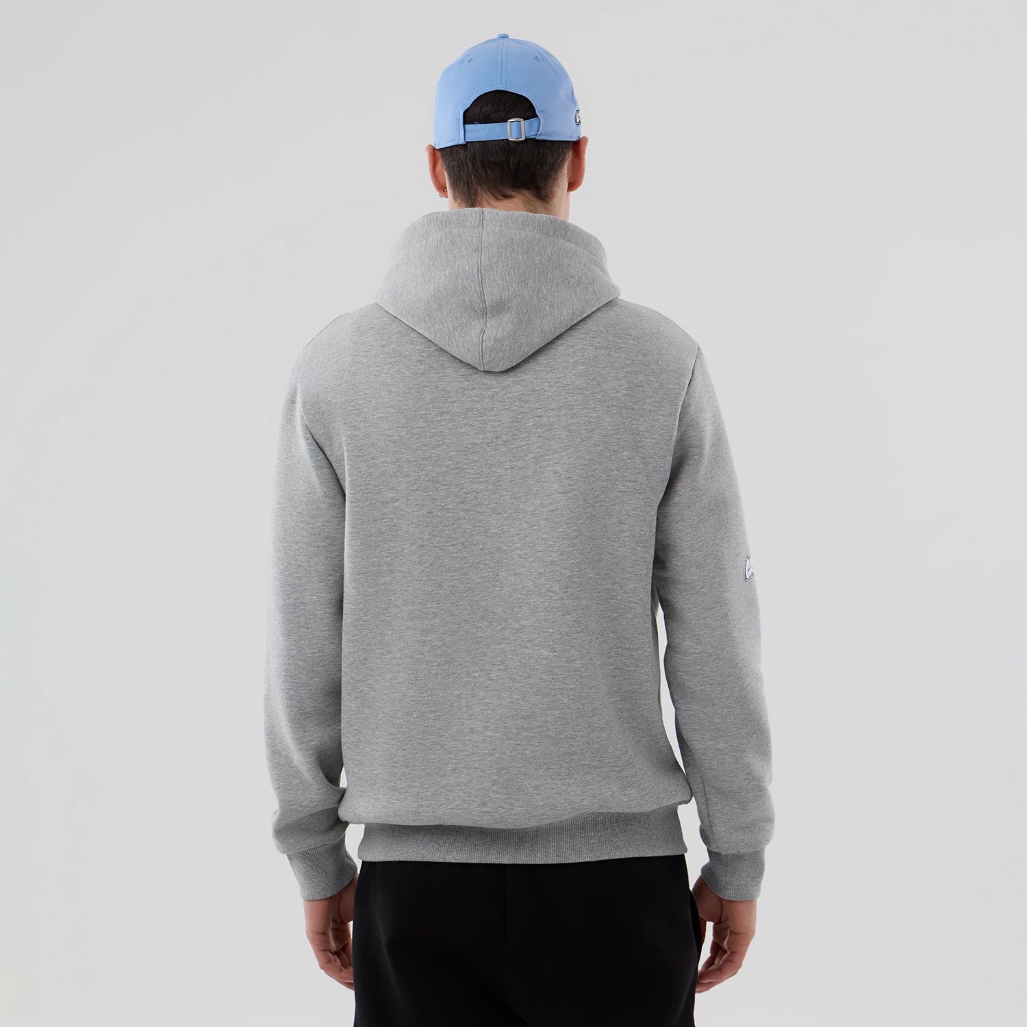 New Era Memphis Grizzlies NBA London Game 2026 Grey Pullover Hoodie, back view on a model, displaying a plain grey design with a relaxed hood, ribbed cuffs, and hem, with a small embroidered logo on the left sleeve.