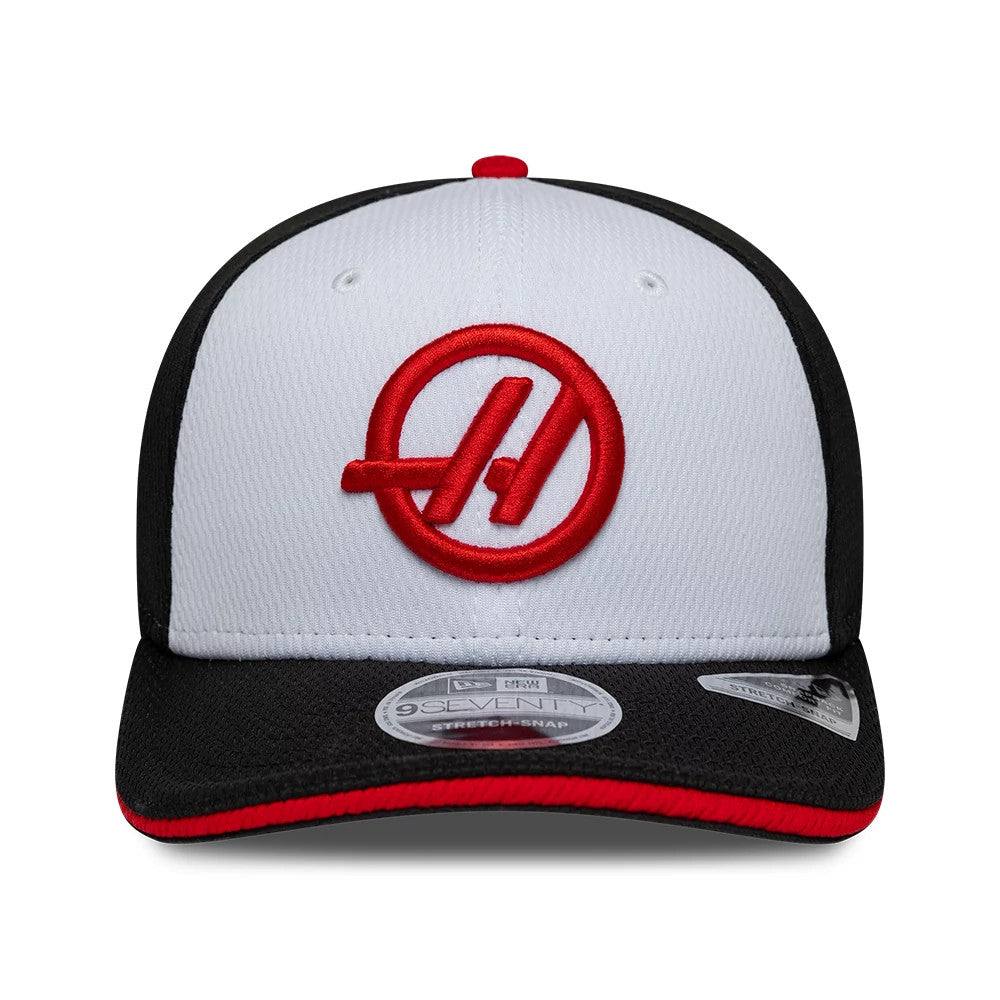 TGR Haas F1 Team Black New Era 9SEVENTY Stretch Snap Adjustable Cap, front view with a large red embroidered A logo on the white front panel, a black visor featuring the 9SEVENTY size sticker, and red edging detail.
