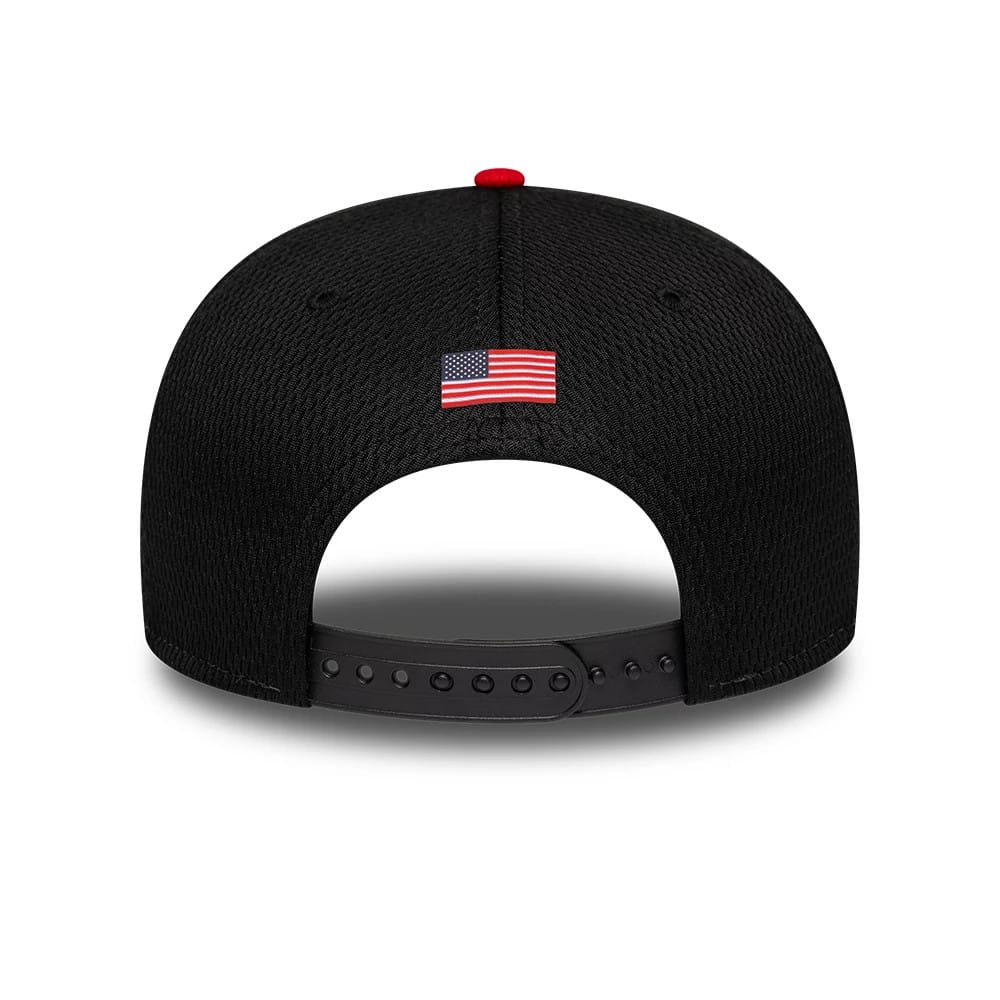 TGR Haas F1 Team Black New Era 9SEVENTY Stretch Snap Adjustable Cap, rear view showing the embroidered American flag logo on the back panels, a black snap closure for adjustable fit, and the red top button on the structured black crown.