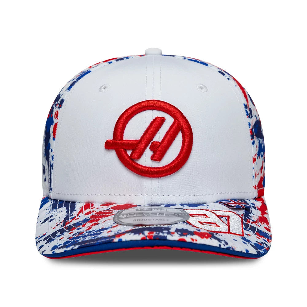 TGR Haas F1 Oliver Bearman Silverstone Race Special White New Era 9SEVENTY Stretch Snap Cap, front view showing the red raised logo embroidery centrally on a white structured crown, a colourful splattered visor design.