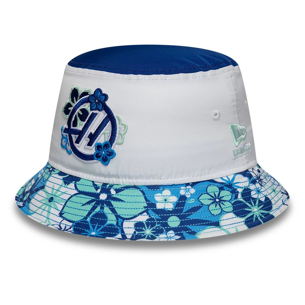 New Era TGR Haas F1 Japan Race Special White Bucket Hat, front view showing an embroidered blue and white floral A logo on the white crown with a blue top panel, New Era flag logo on the side, and a floral pattern on the visor.