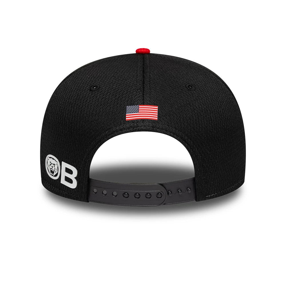 TGR Haas F1 Oliver Bearman Black New Era 9SEVENTY Stretch Snap Cap, rear view showing the embroidered American flag at the centre back, a red top button, and a white OB logo on the left side above the adjustable snap closure.
