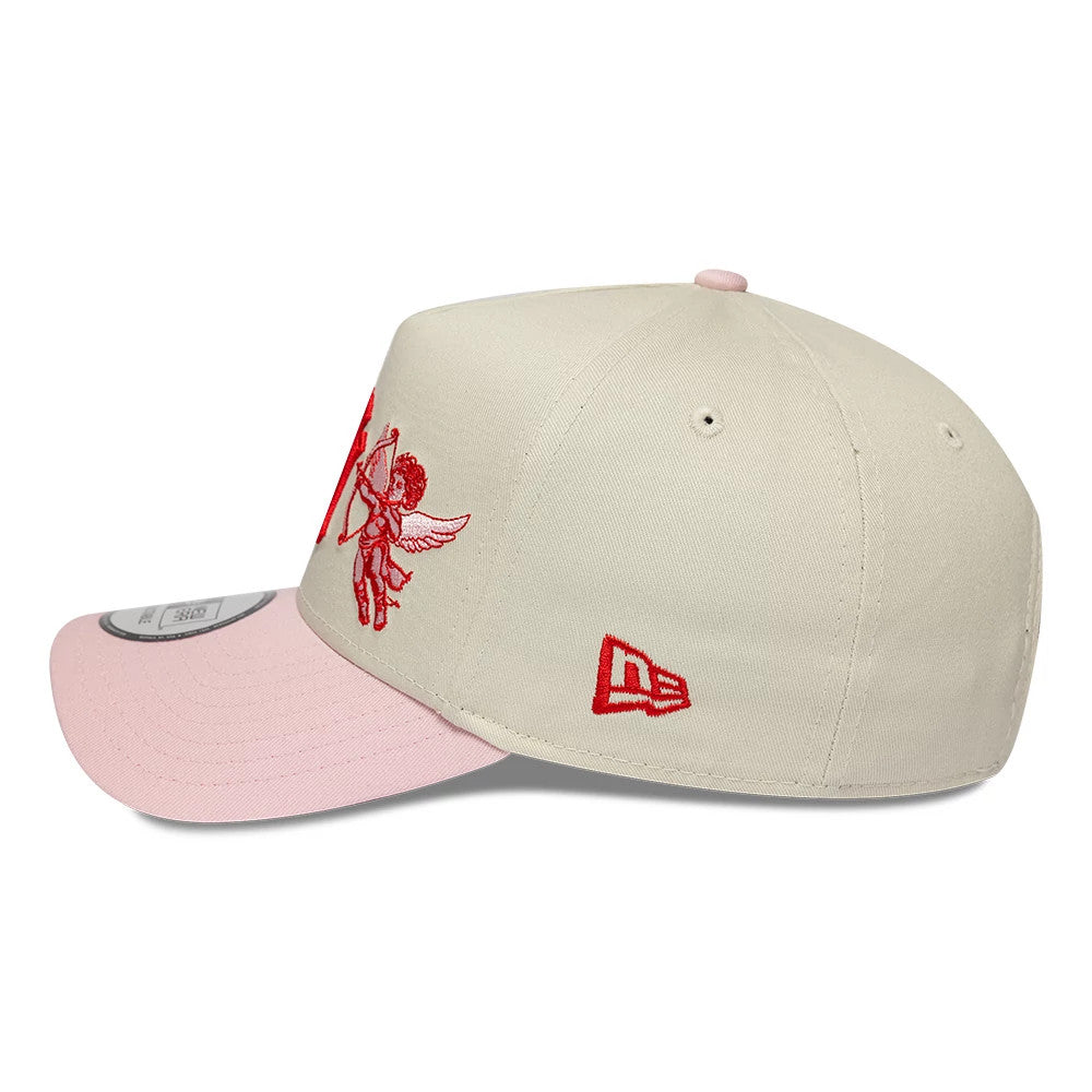 New York Yankees MLB Cherub Cream & Pink New Era 9FORTY A-Frame Adjustable Cap, side view showing the red cherub and Yankees lettering embroidered on the front panel, with a contrasting pink visor and the New Era flag logo on the left side.