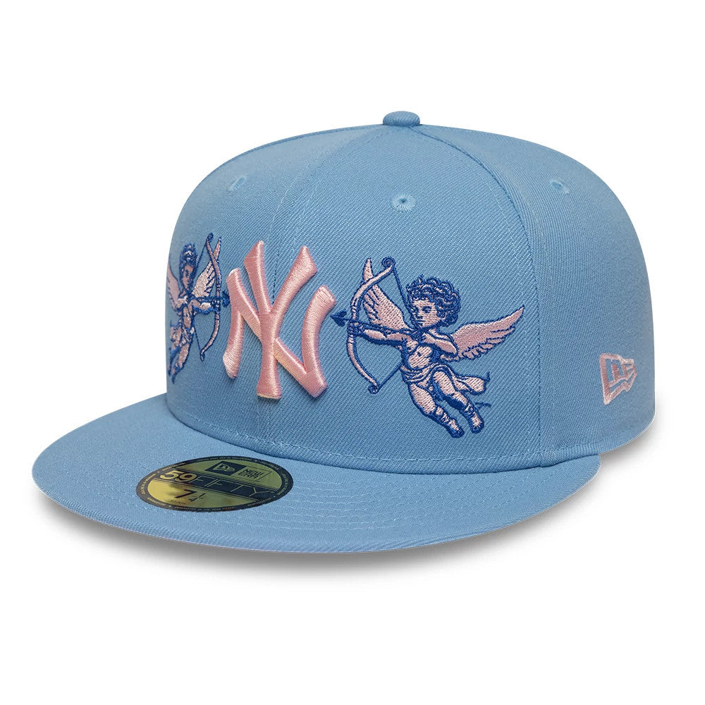 New York Yankees MLB Cherub Pastel Blue New Era 59FIFTY Fitted Cap, front view showing pink raised embroidery NY logo on the structured pastel blue crown, with blue cherub graphics on the front panel and a gold 59FIFTY size sticker on the flat visor.