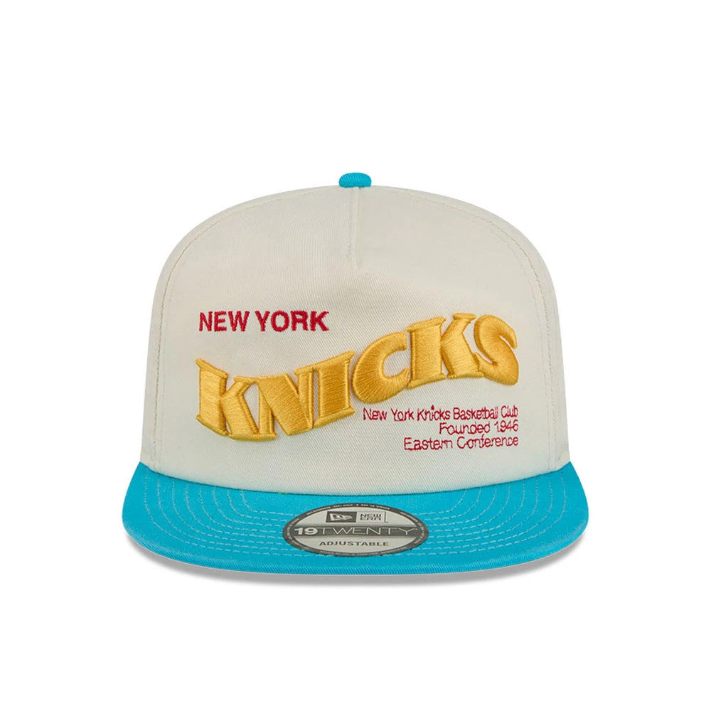 New York Knicks NBA Conference Script White New Era 19TWENTY Adjustable Cap, front view showing raised yellow Knicks lettering below red New York embroidery on a cream crown with additional red script text, and a bright blue flat visor.