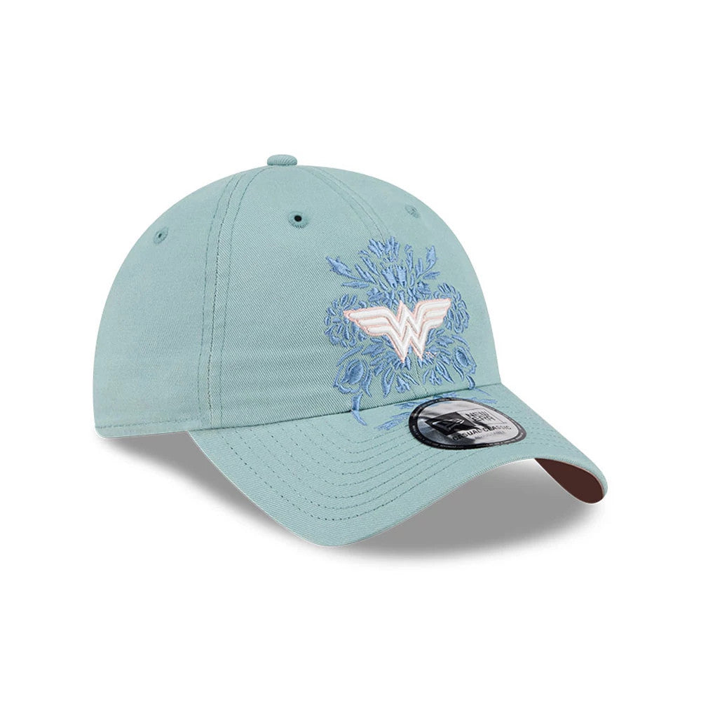 New Era Womens DC Wonder Woman Pastel Blue Casual Classic Adjustable Cap, three-quarter view showing a raised pink Wonder Woman logo embroidered on the front panel with floral accents, curved pastel blue visor.