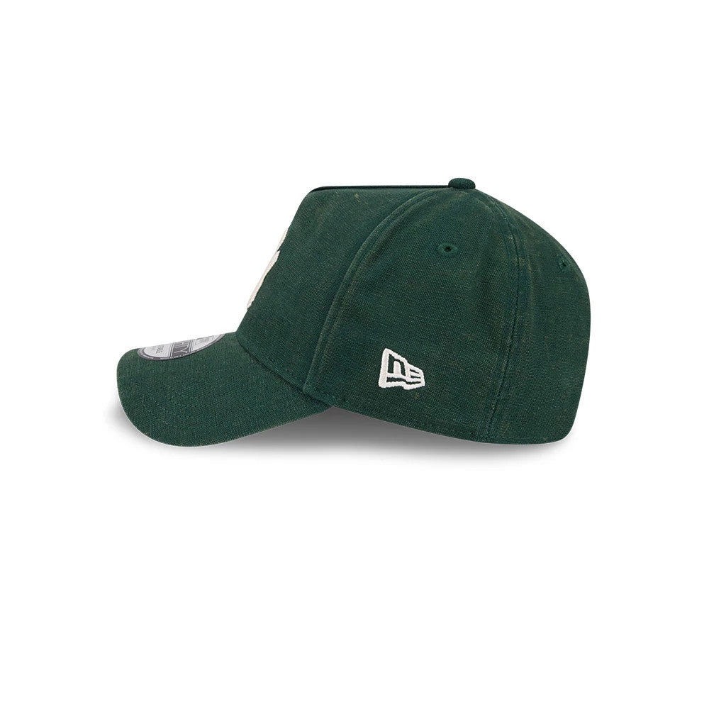 Yankees MLB Washed Canvas Dark Green New Era 9FORTY A-Frame Adjustable Cap, side view showing the white embroidered New Era flag logo on the left side, with a curved visor featuring a 9FORTY size sticker, and a structured dark green canvas crown.