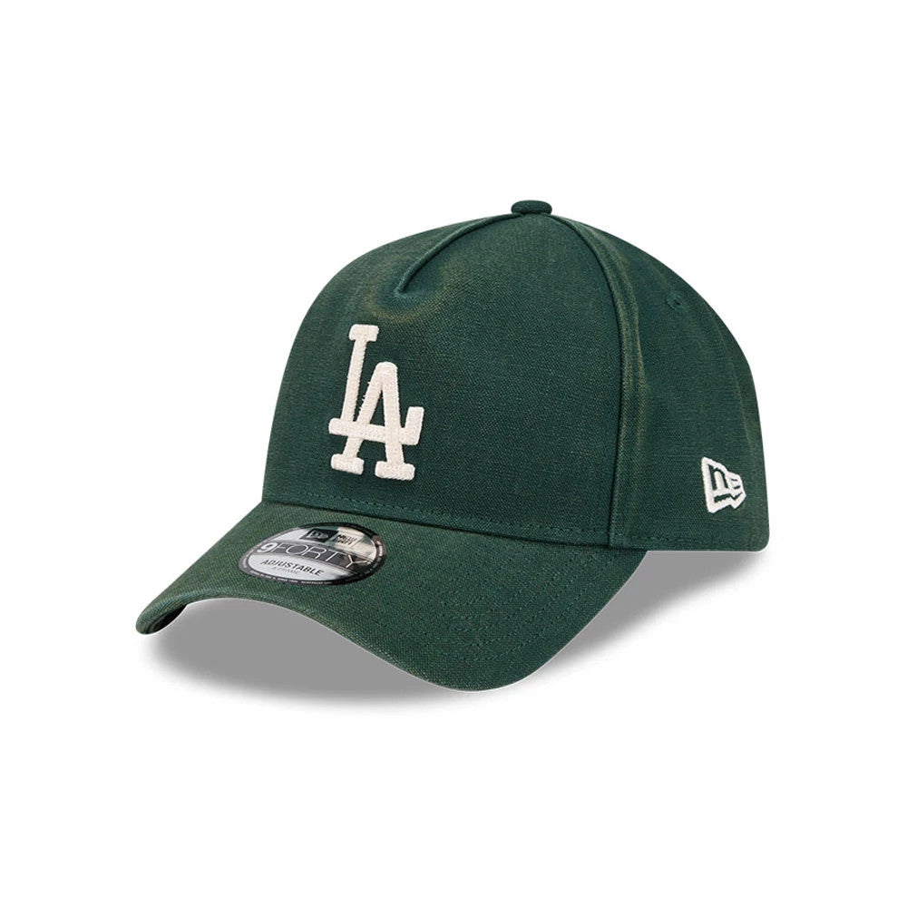 LA Dodgers MLB Washed Canvas Dark Green New Era 9FORTY A-Frame Adjustable Cap, three-quarter view showing raised white LA logo embroidery on the front panel, curved dark green visor with a 9FORTY size sticker, and New Era flag logo on the left side.