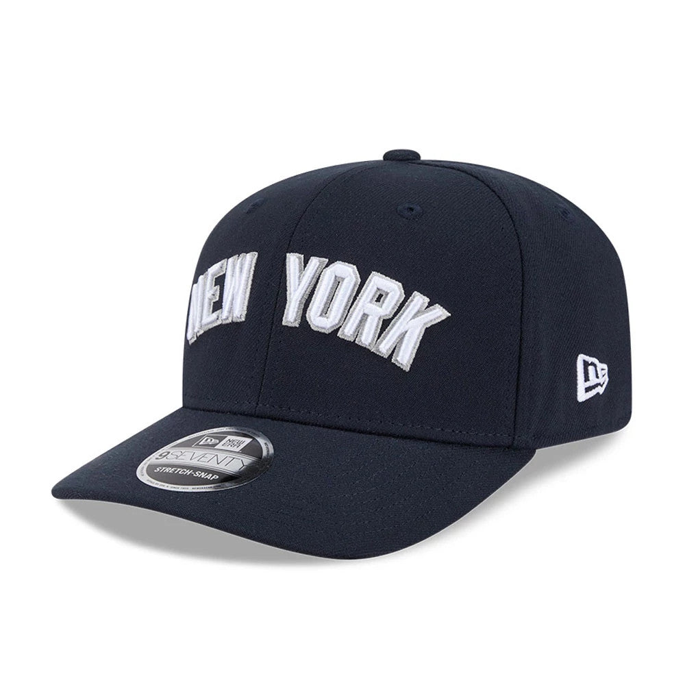New York Yankees MLB Navy New Era 9SEVENTY Stretch Snap Adjustable Cap, front view showing raised white embroidered New York lettering on the structured navy crown, with the New Era flag logo on the left side and a 9SEVENTY size sticker on the visor.