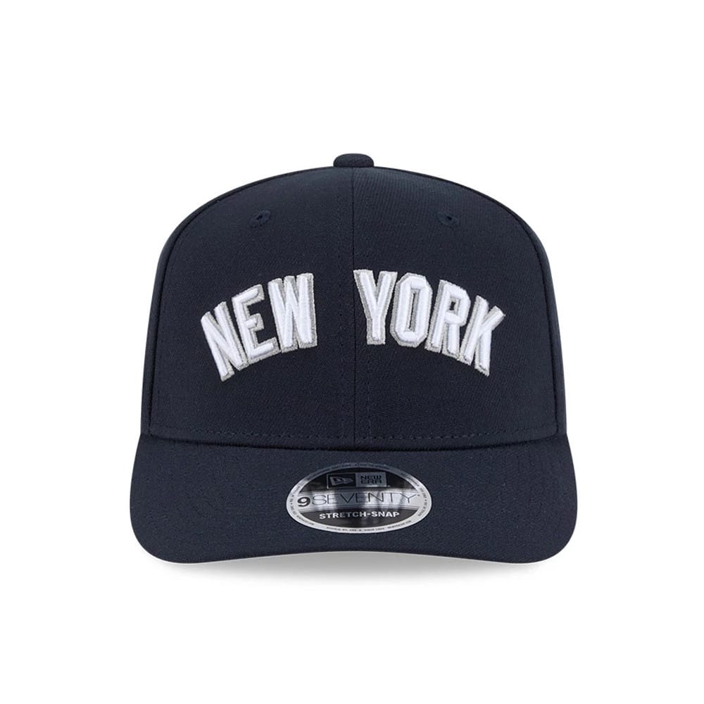 New York Yankees MLB Navy New Era 9SEVENTY Stretch Snap Adjustable Cap, front view showing raised white embroidered NEW YORK lettering across the front panel, with a curved navy visor and a 9SEVENTY size sticker on the centre of the visor.