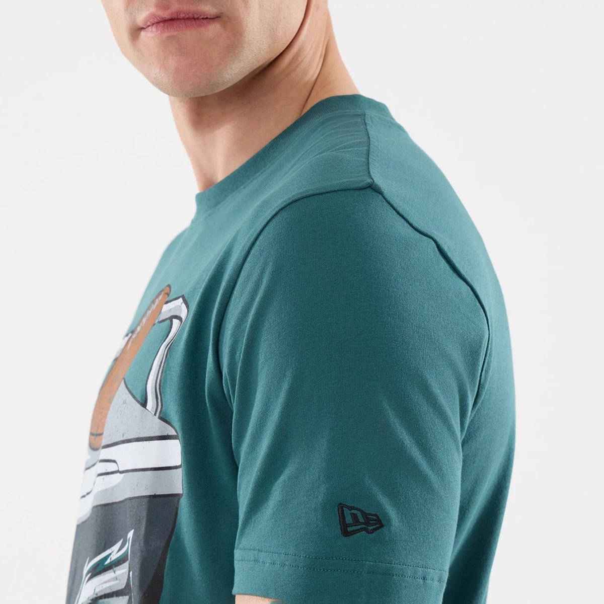 New Era Philadelphia Eagles NFL Training 2026 Dark Green T-Shirt, three-quarter view on a model showcasing a front graphic featuring team elements, with a black embroidered New Era logo located on the left sleeve close to the cuff.