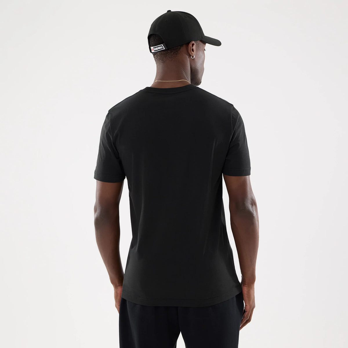 New Era Las Vegas Raiders NFL Training 2026 Black T-Shirt, back view on a model wearing a matching black cap, showing a plain black back with short sleeves and a simple crew neck, providing a and minimalist style.