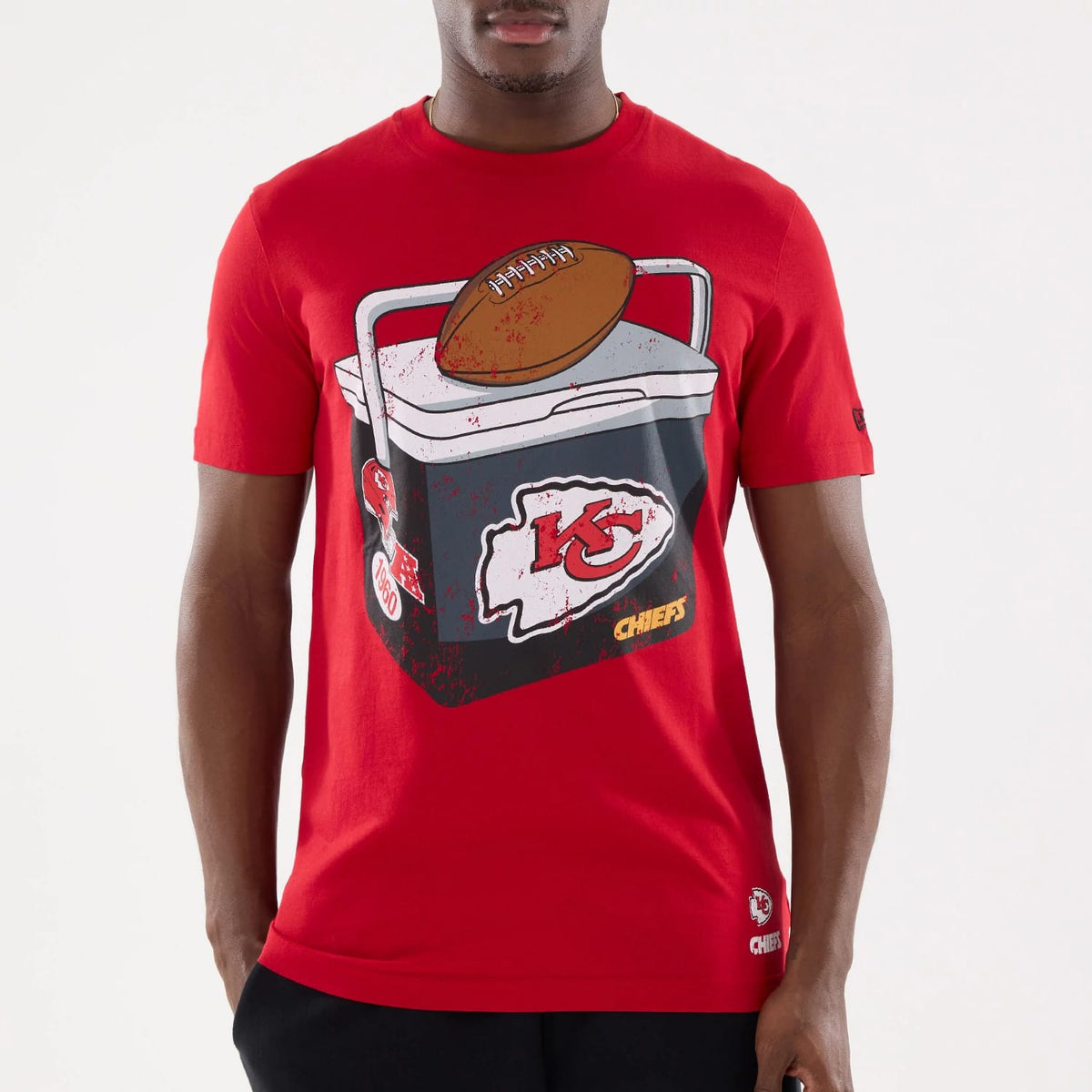 New Era Kansas City Chiefs NFL Training 2026 Red T-Shirt, front view on-model displaying a graphic of an American football on an ice chest with the Chiefs logo, matching sleeve branding, and a small logo at the hem.