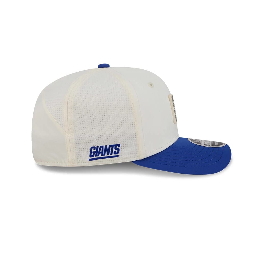 New York Giants NFL Training 2026 White New Era 9SEVENTY Stretch Snap Adjustable Cap, side view showing the blue embroidered Giants logo on the white side panel, with a blue visor and a 9SEVENTY size sticker on the visor.