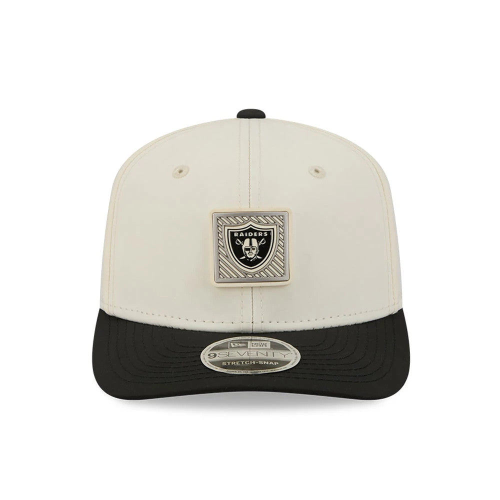 Raiders NFL Training 2026 White New Era 9SEVENTY Stretch Snap Adjustable Cap, front view showing the raised rectangular Raiders logo badge on the front panel, with a contrasting black curved visor and a 9SEVENTY size sticker on the visor.