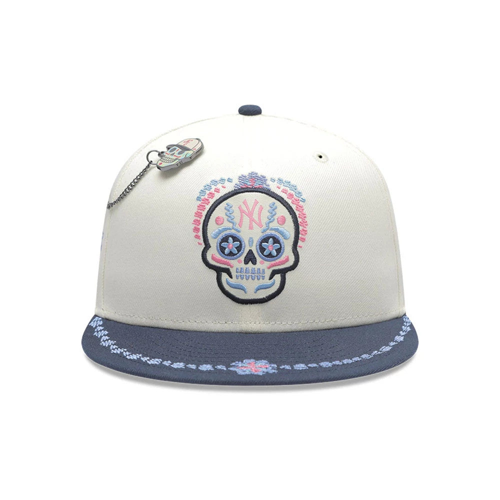 Pictured is this MLB Day Of The Dead New York Yankees 59FIFTY Fitted cap in light beige & dark blue. 2
