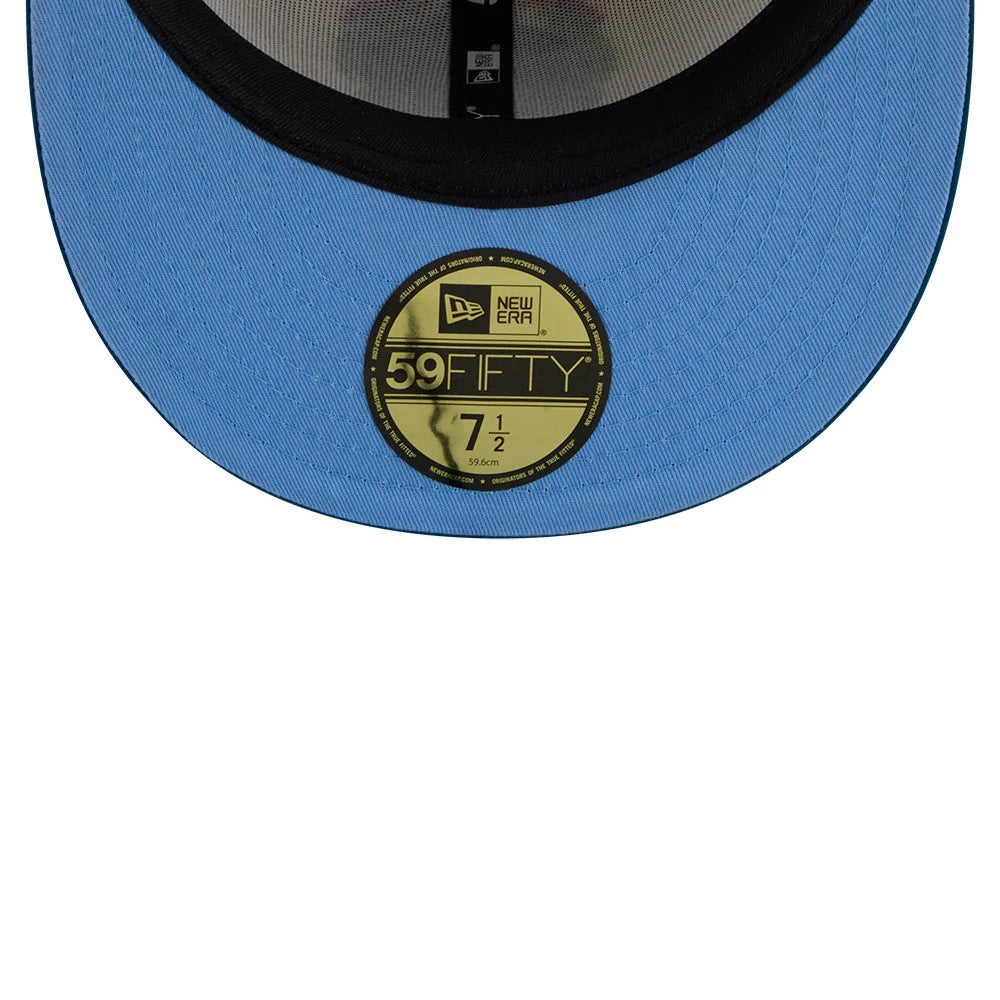 New Era Day Of The Dead Light Beige & Blue 59FIFTY Fitted Cap, inside view showing the light blue undervisor, gold 59FIFTY size sticker on the visor, and grey interior taping with a black sweatband.
