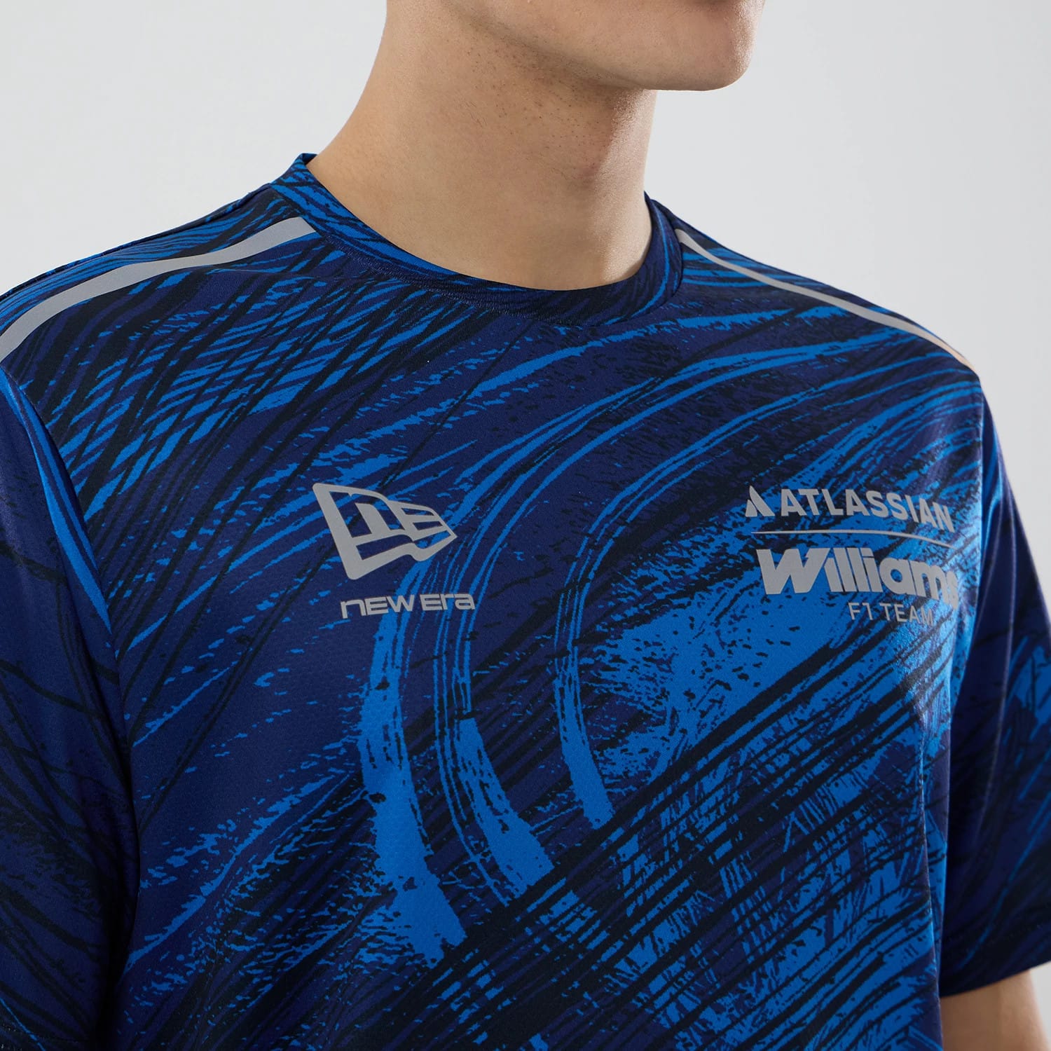 New Era Williams Navy Active T-Shirt, front view showing a dynamic blue and black pattern, an embroidered New Era logo on the chest, and white Williams F1 Team lettering with the Atlassian logo above on the upper right.