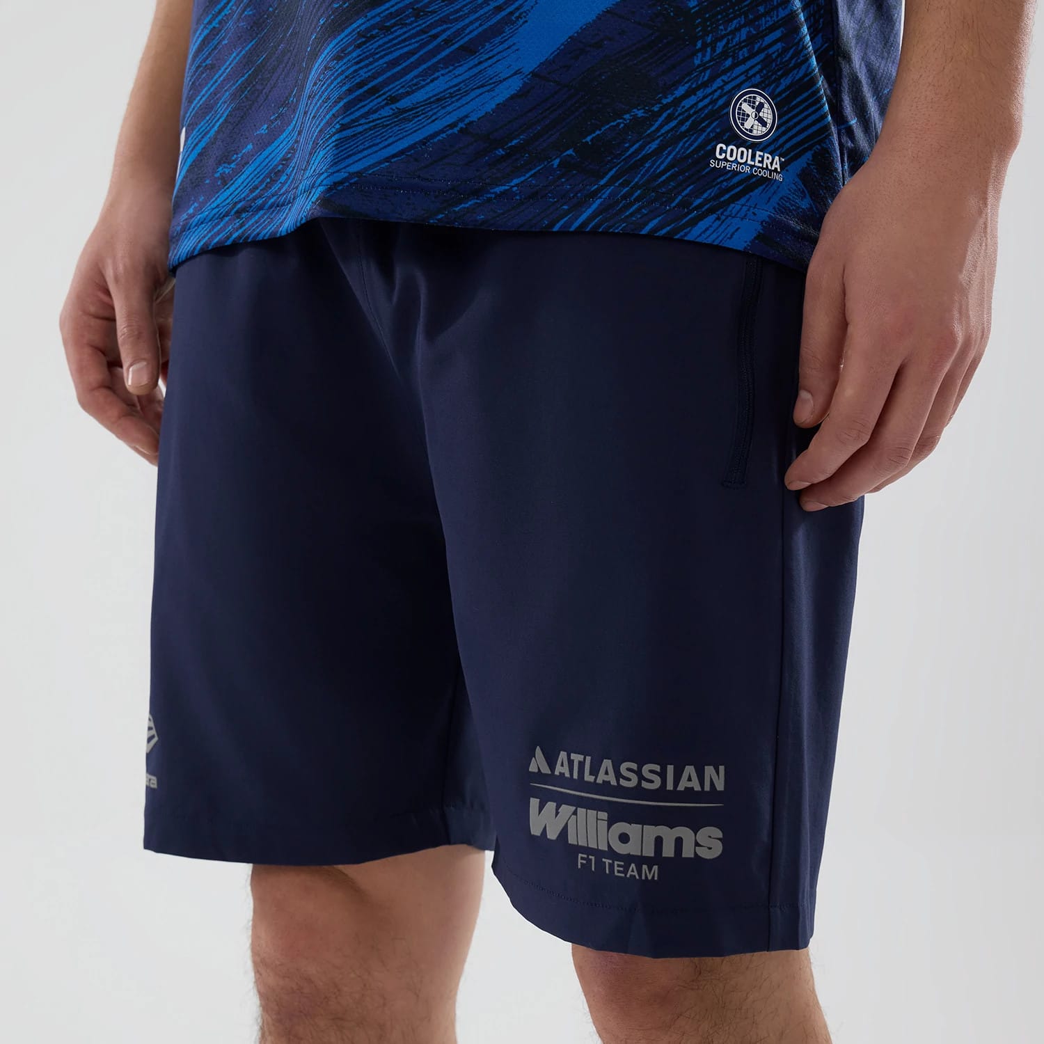 New Era Williams Navy Training Shorts, front view on-model showing a deep navy colour with the Williams F1 Team logo prominently printed on the left leg, Atlassian branding above, and a small New Era logo printed on the right side.