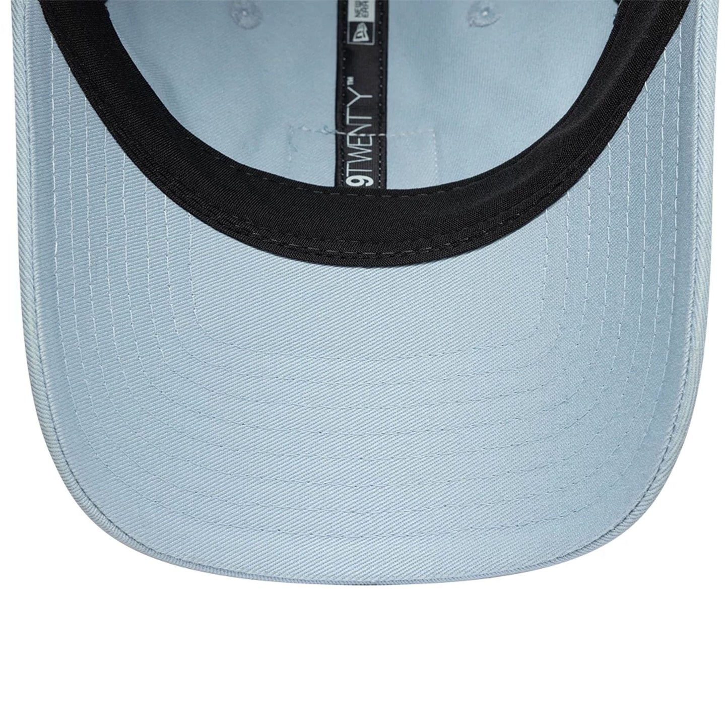 Lacoste X New Era Pastel Blue 9TWENTY Adjustable Cap, inside view showing the light blue undervisor contrasted by a black sweatband, with the black 9TWENTY fabric taping running down the centre.