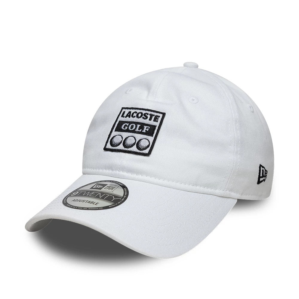 Lacoste X New Era Golf White 9TWENTY Adjustable Cap, front view showing the embroidered Lacoste Golf logo with three golf balls on the front panel, curved white visor with 9TWENTY size sticker, and New Era flag logo on the left side.