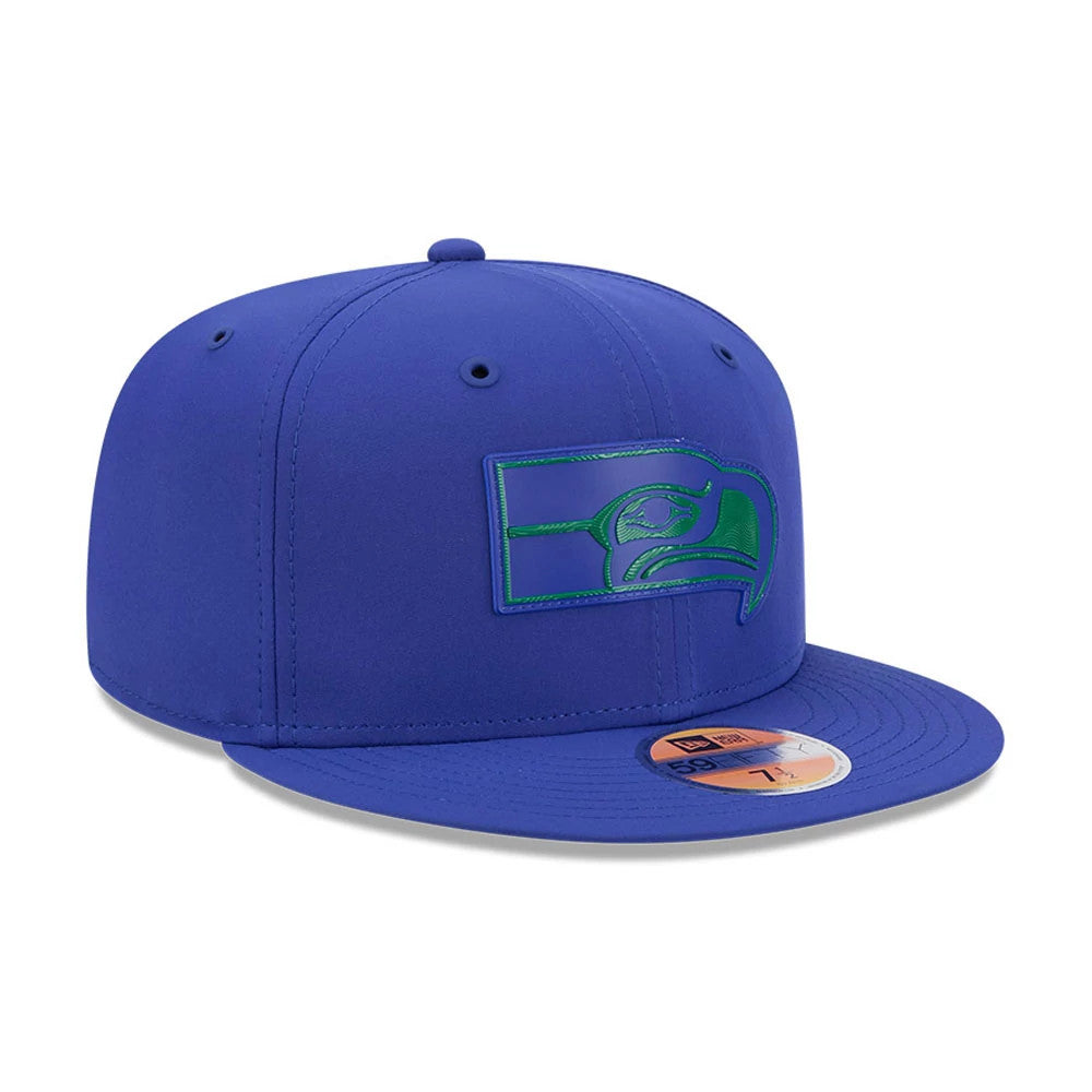 Seattle Seahawks NFL Sideline 2026 Blue New Era 59FIFTY Fitted Cap, three-quarter view showing an embossed green and blue Seahawks logo on the front panel, complementing the flat blue visor with a gold 59FIFTY size sticker.