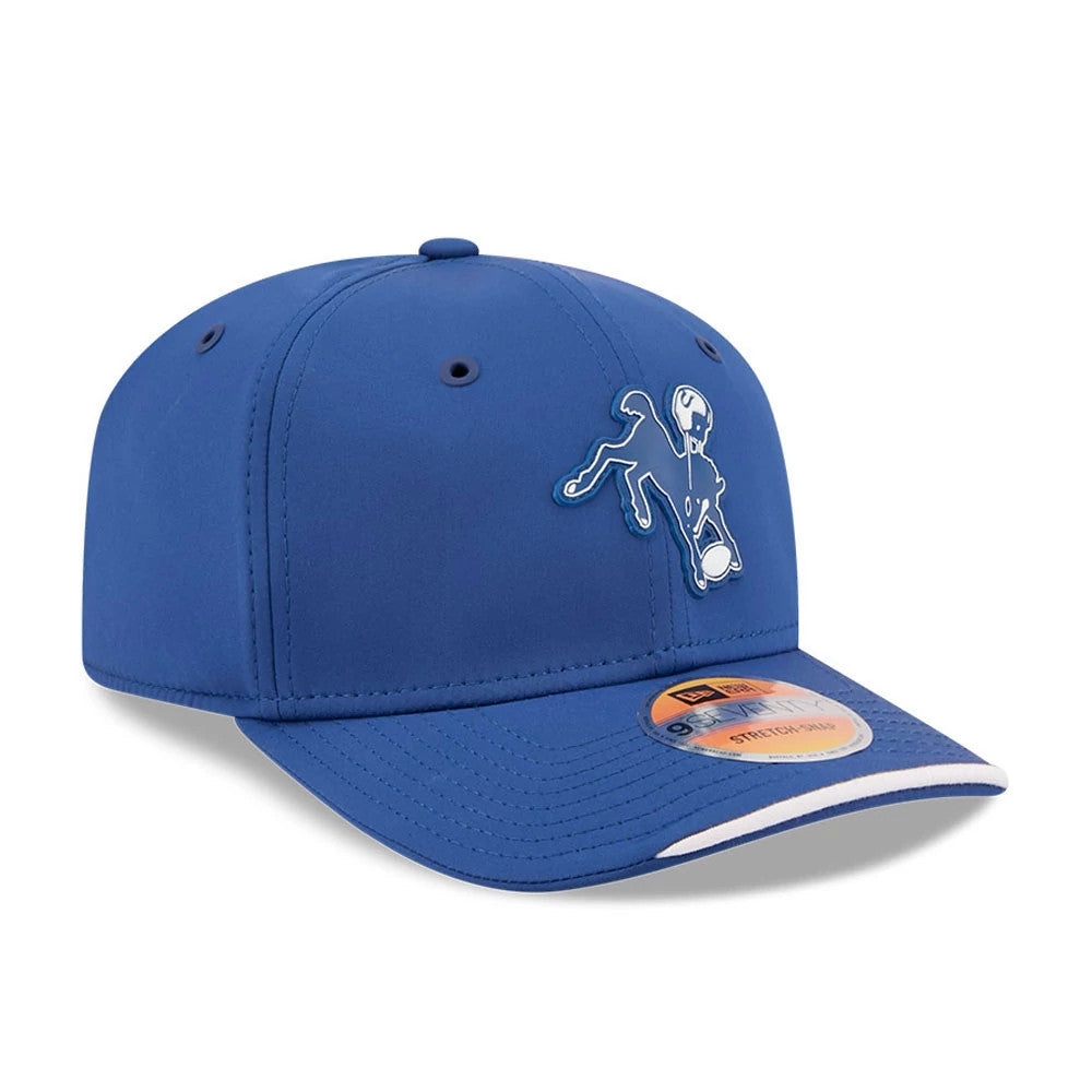 Colts NFL Sideline 2026 Blue New Era 9SEVENTY Stretch Snap Adjustable Cap, three-quarter view showing a raised embroidered white and blue Colts logo on the front panel, with a curved blue visor and a 9SEVENTY size sticker on top.