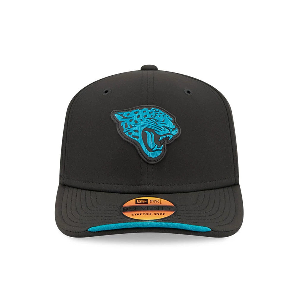 Jaguars NFL Sideline 2026 Black New Era 9SEVENTY Stretch Snap Adjustable Cap, front view showing a raised teal jaguar head embroidered on the front panel, a black visor with teal trim on the edge, and a brown 9SEVENTY size sticker on the visor.