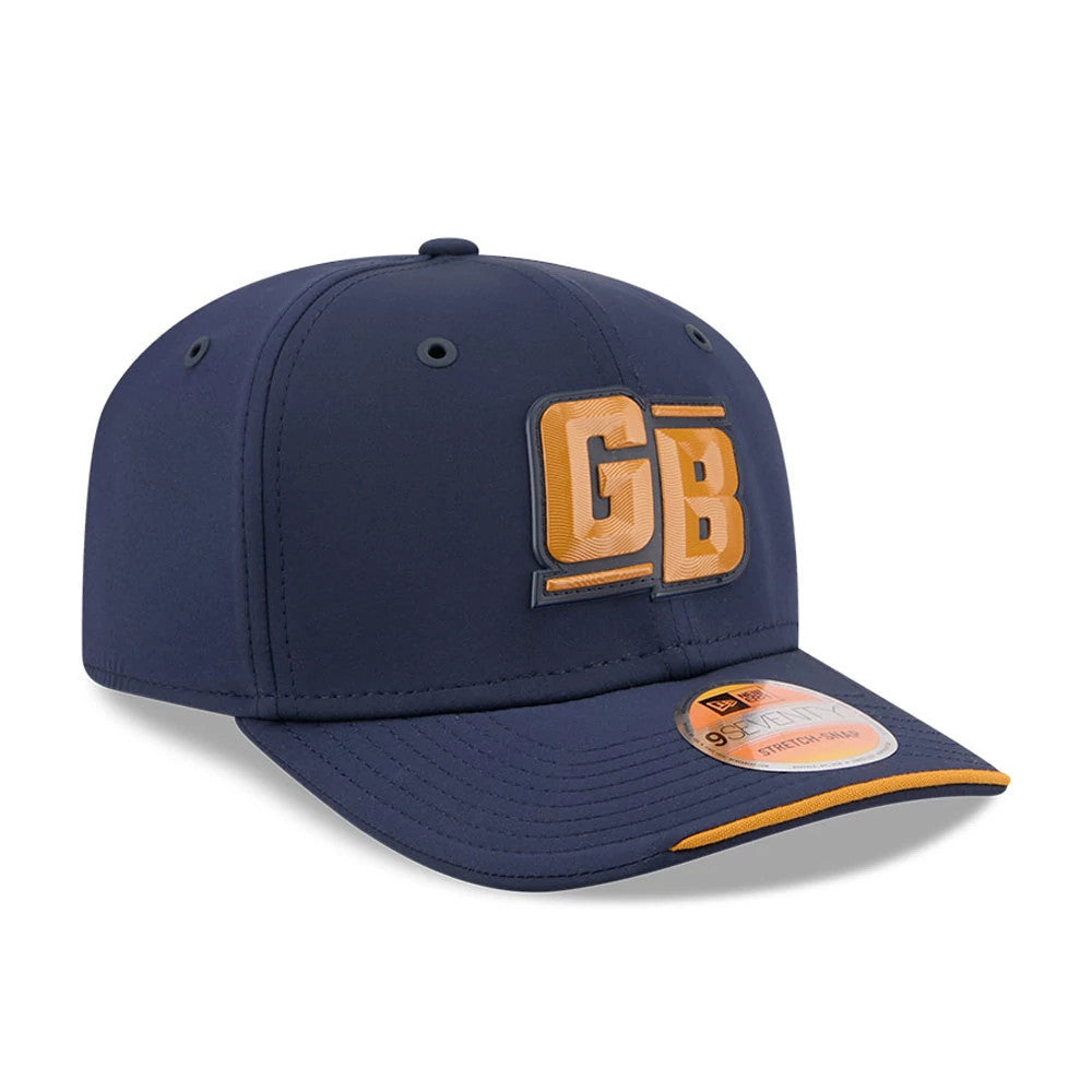 Packers NFL Sideline 2026 Dark Blue New Era 9SEVENTY Stretch Snap Adjustable Cap, three-quarter view showing raised gold GB embroidery on the structured dark blue front panel, a curved dark blue visor with gold edging, and a 9SEVENTY size sticker.