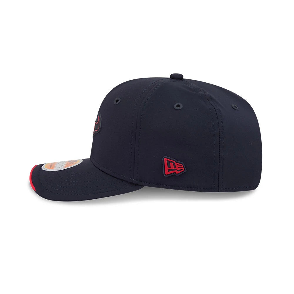 Texans NFL Sideline 2026 Navy New Era 9SEVENTY Stretch Snap Adjustable Cap, side view showing the red embroidered New Era flag logo on the left side, navy curved visor with a red edge, and a 9SEVENTY size sticker on top.