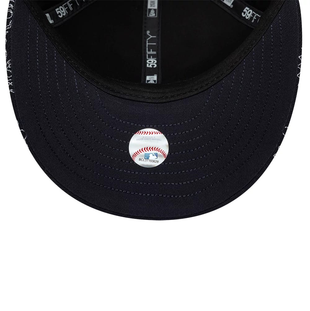 New York Yankees MLB All Over Paisley Navy Low Profile New Era 59FIFTY Fitted Cap, inside view showing the black undervisor with detailed stitching, grey taping marked with 59FIFTY branding, and a baseball design sticker in the centre.