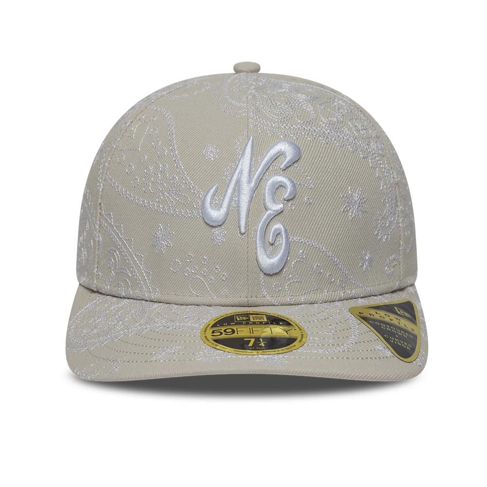 New Era All Over Paisley Cream Low Profile 59FIFTY Fitted Cap, front view showing raised white NE embroidery on the structured cream crown with detailed paisley pattern, flat visor, and a gold 59FIFTY size sticker placed prominently.