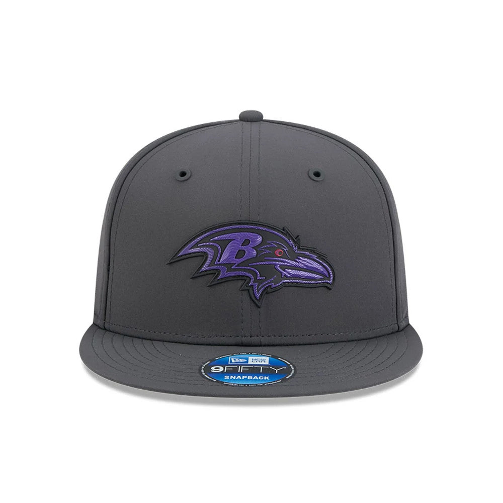 Ravens NFL Sideline 2026 Charcoal New Era 9FIFTY Snapback Adjustable Cap, front view showing a purple embroidered Ravens logo on the structured charcoal crown, with a flat charcoal visor and a 9FIFTY size sticker on the visor.