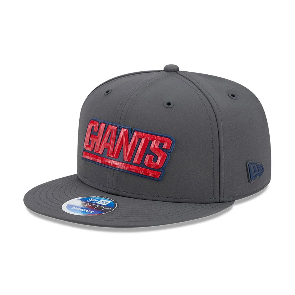 New York Giants NFL Sideline 2026 Charcoal New Era 9FIFTY Snapback Adjustable Cap, three-quarter view showing raised red GIANTS embroidery on the front panel, a dark grey flat visor with a 9FIFTY size sticker.
