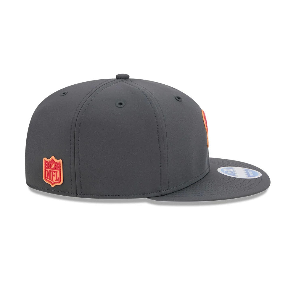 Buccaneers NFL Sideline 2026 Charcoal New Era 9FIFTY Snapback Adjustable Cap, side view showing the raised orange NFL logo patch on the centre back, the structured charcoal grey crown, and the flat charcoal visor with a blue 9FIFTY size sticker.