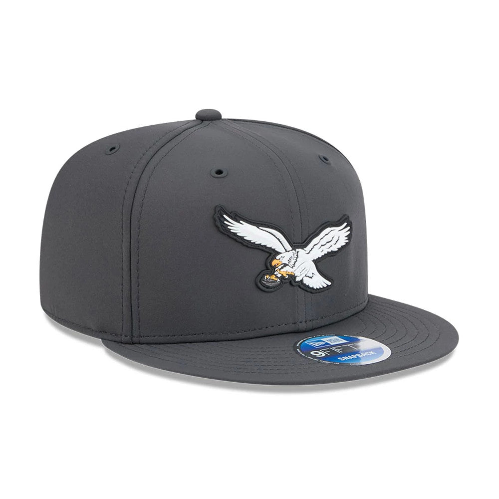 Eagles NFL Sideline 2026 Charcoal New Era 9FIFTY Snapback Adjustable Cap, front view showing the prominently embroidered white eagle logo on the structured charcoal crown, flat charcoal visor, and the blue 9FIFTY size sticker on the visor.