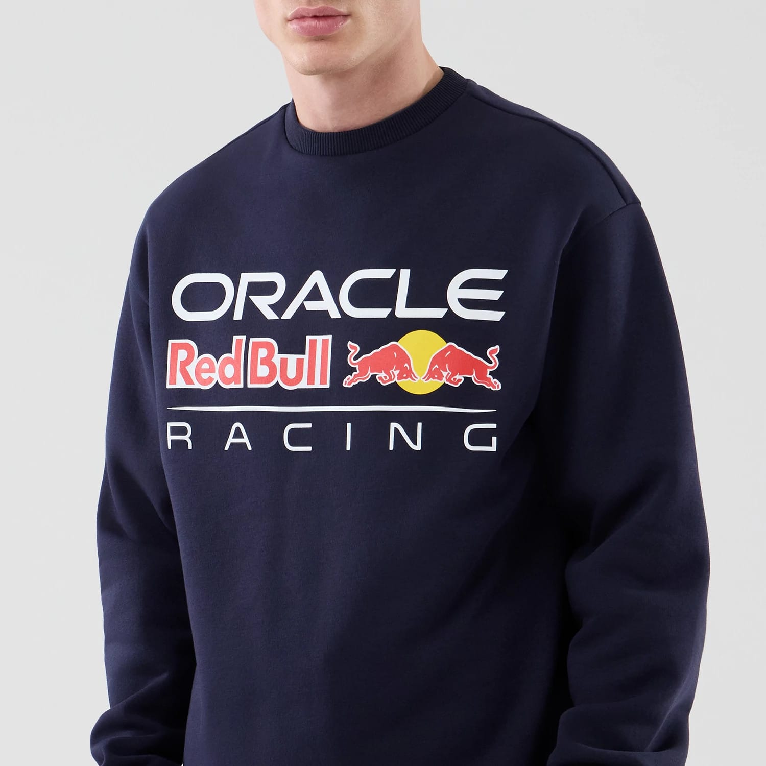 The model is wearing this Red Bull Racing Oversized Crew Neck Sweater in dark blue. 3