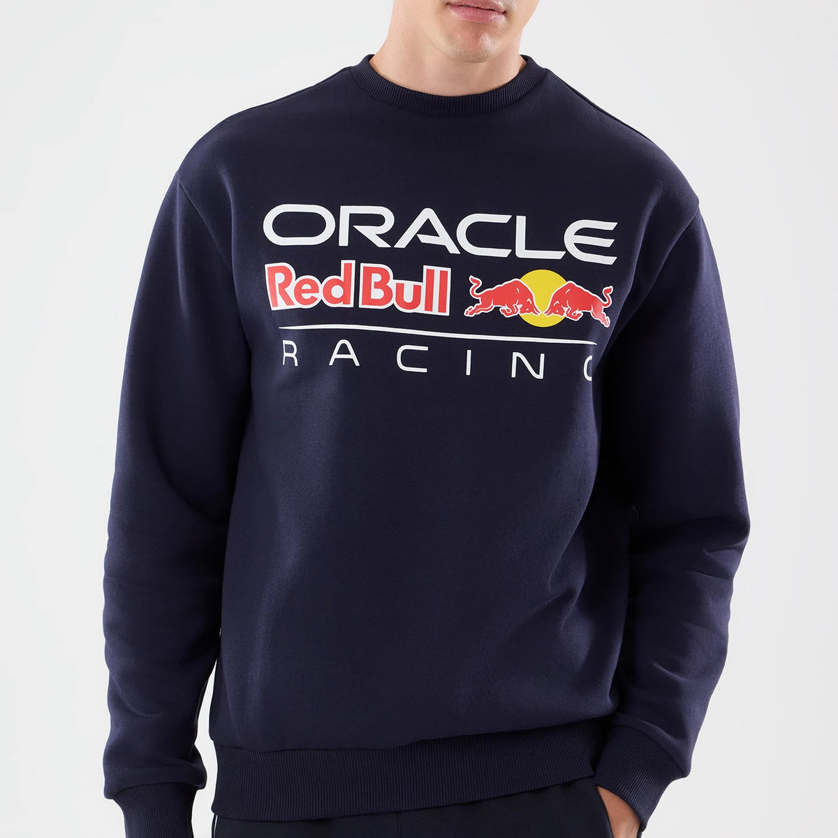 New Era Red Bull Racing Dark Blue Oversized Crew Neck Sweater, front view on a model featuring a prominent Oracle logo in white, Red Bull emblem with the red bulls and yellow sun, and Racing lettering across the chest.