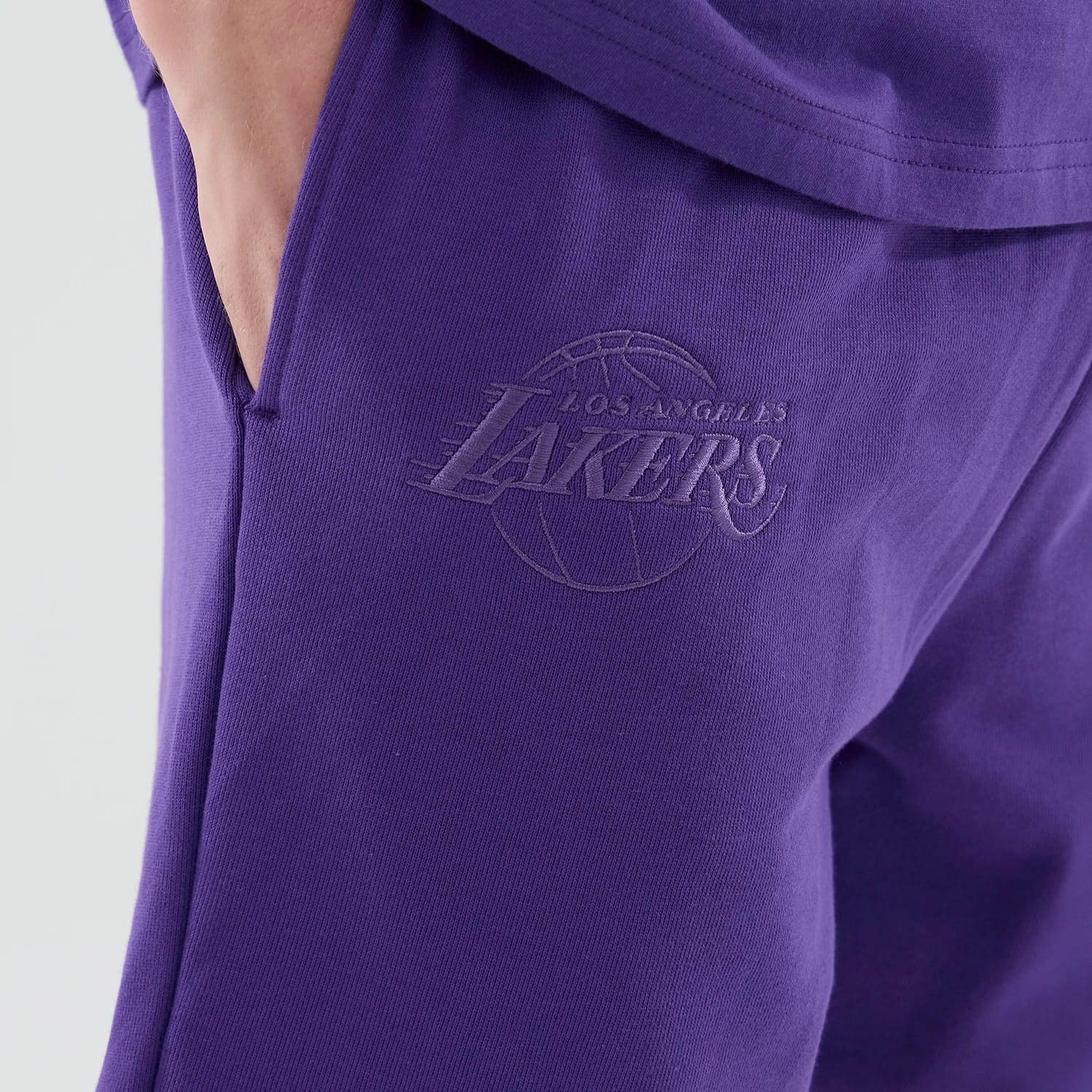 The model is wearing these NBA League Essential LA Lakers Oversized Shorts in purple. 4