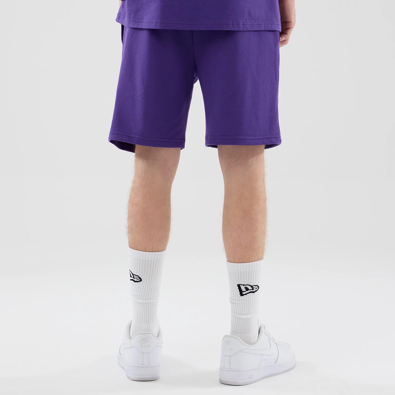 The model is wearing these NBA League Essential LA Lakers Oversized Shorts in purple. 2